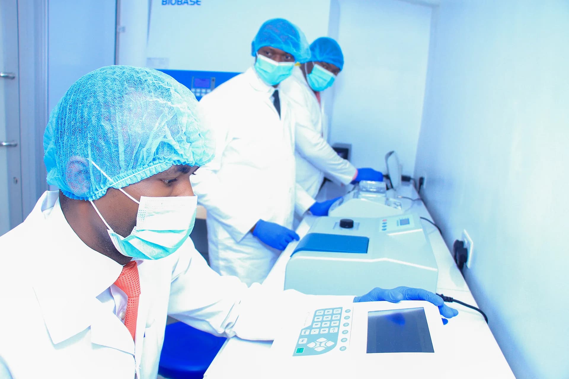 Everight scientists in full PPE operating real-time PCR thermocyclers inside the Level-3 biosafety molecular laboratory